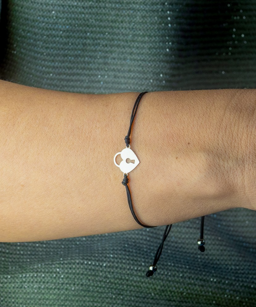 Black string bracelet with a silver pendant