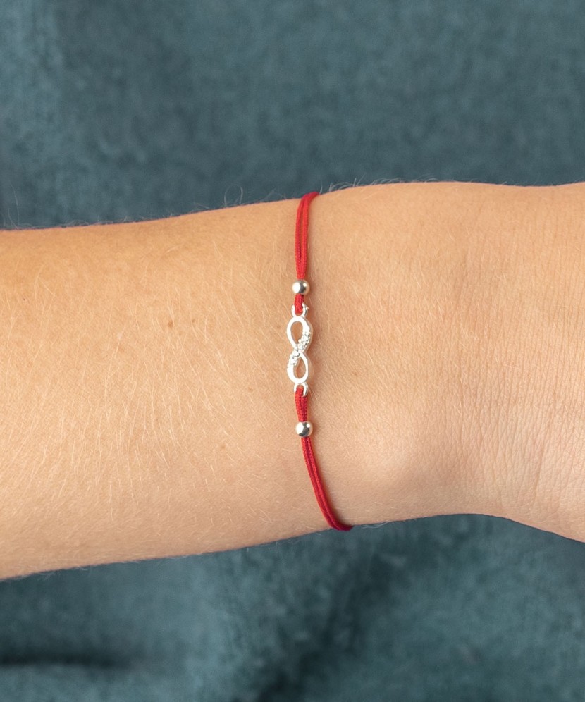 Red string bracelet with a silver pendant "Infinity"