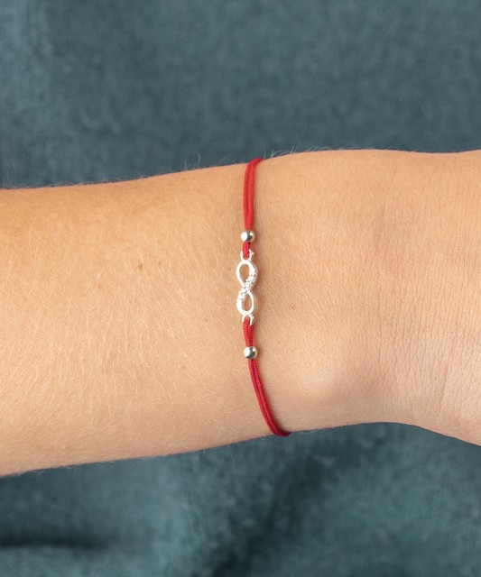 Red string bracelet with a silver pendant "Infinity"