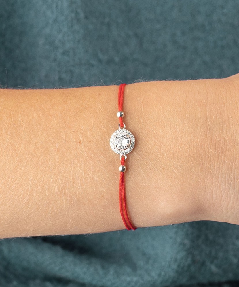 Red string bracelet with a silver pendant with zirconium