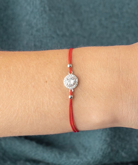 Red string bracelet with a silver pendant with zirconium
