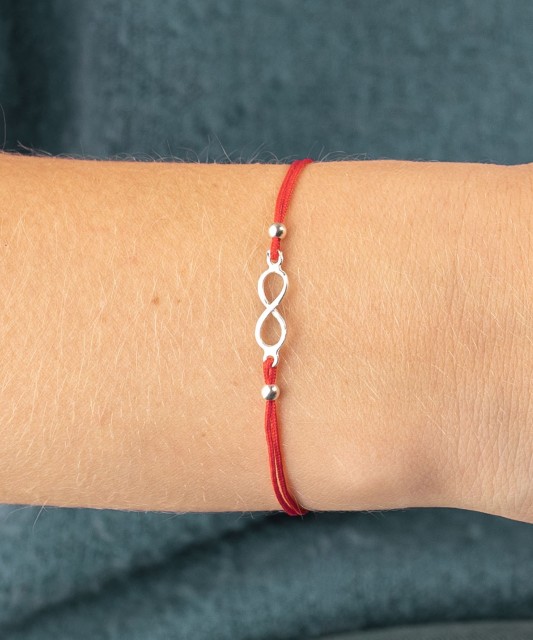 Red string bracelet with a silver pendant "Infinity"