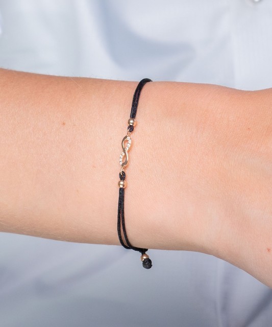 Black string bracelet with a gold pendant and zirconium