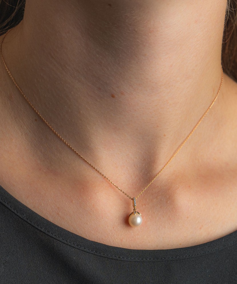 Kultainen riipus helmelläja timantteja