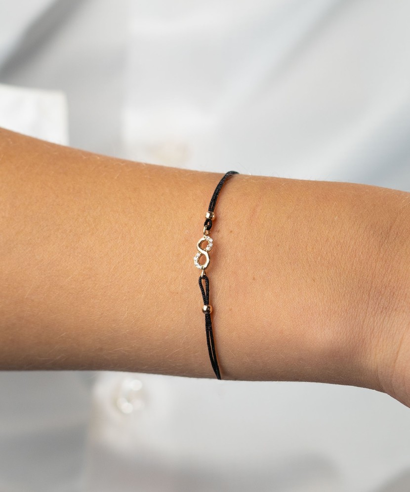 Black string bracelet with a gold pendant "Infinity"