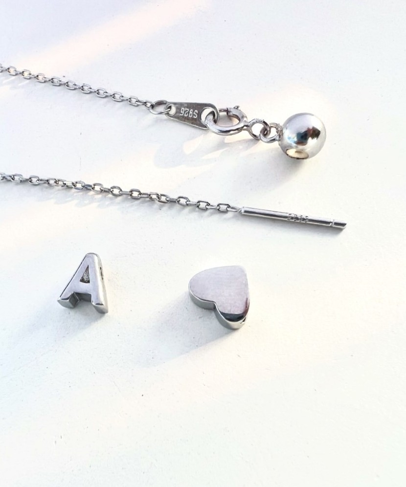 Hopeinen ketju riipuksella kirje J