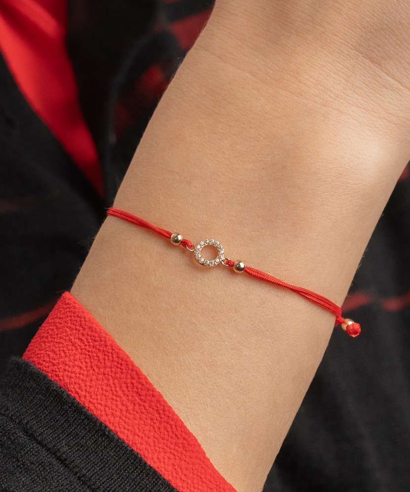 Red string bracelet with a gold pendant and zirconium