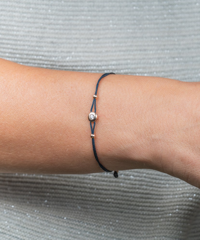 Black string bracelet with gold pendant