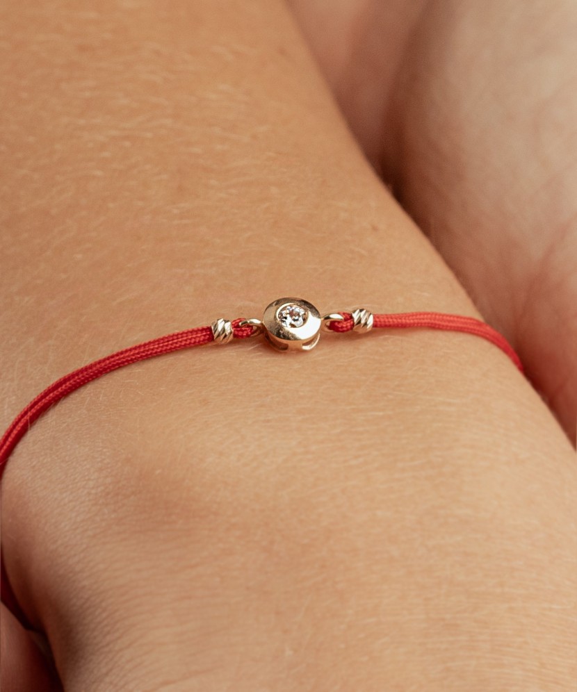 Black string bracelet with gold pendant