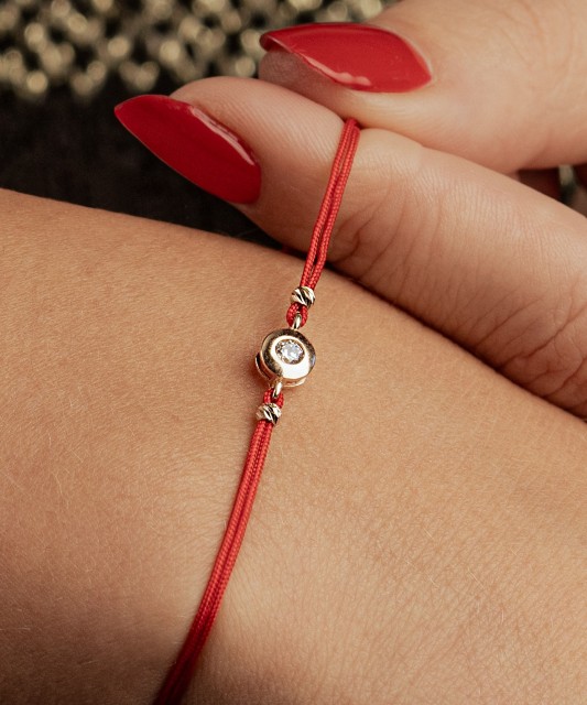 Black string bracelet with gold pendant