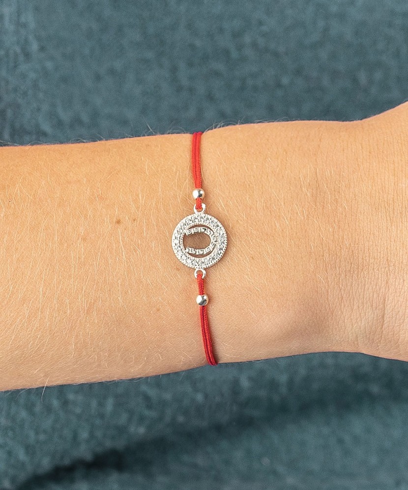 Red string bracelet with a silver pendant "horseshoe"