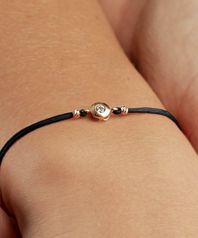 Black string bracelet with gold pendant