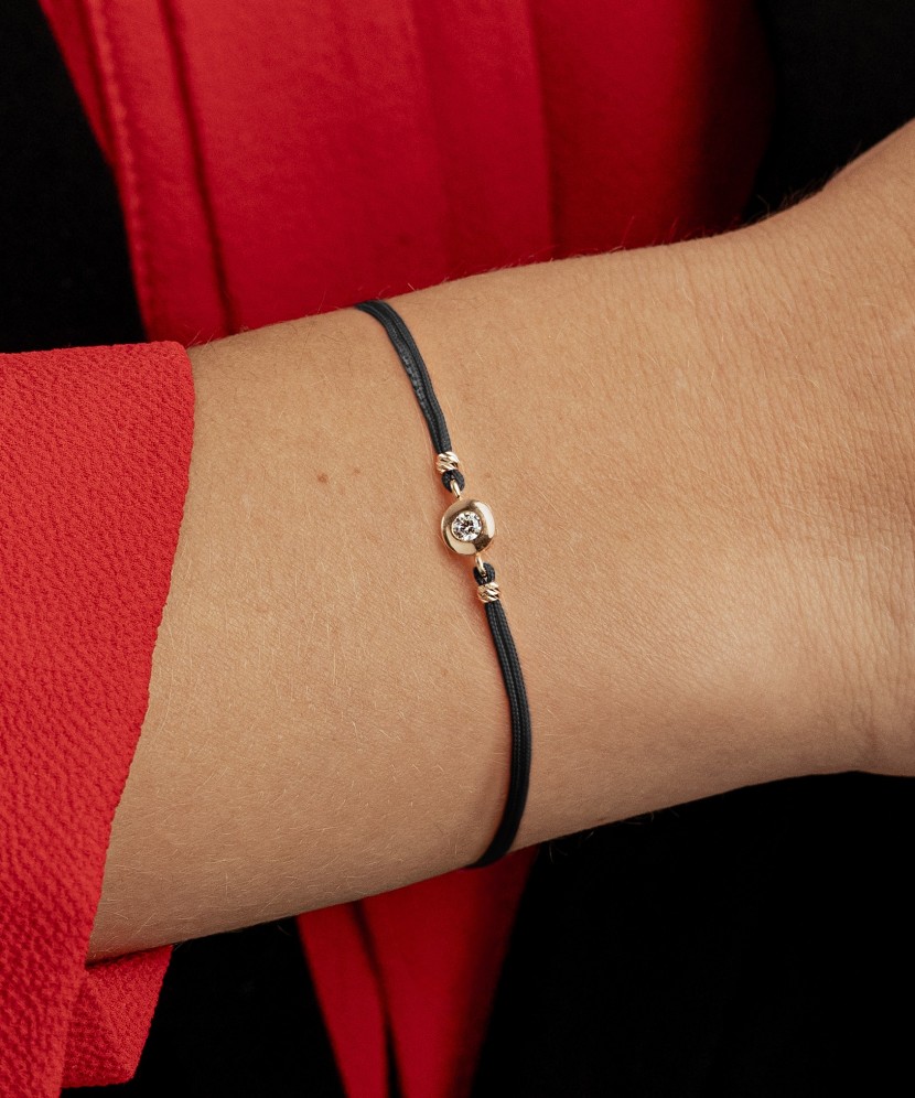 Black string bracelet with gold pendant