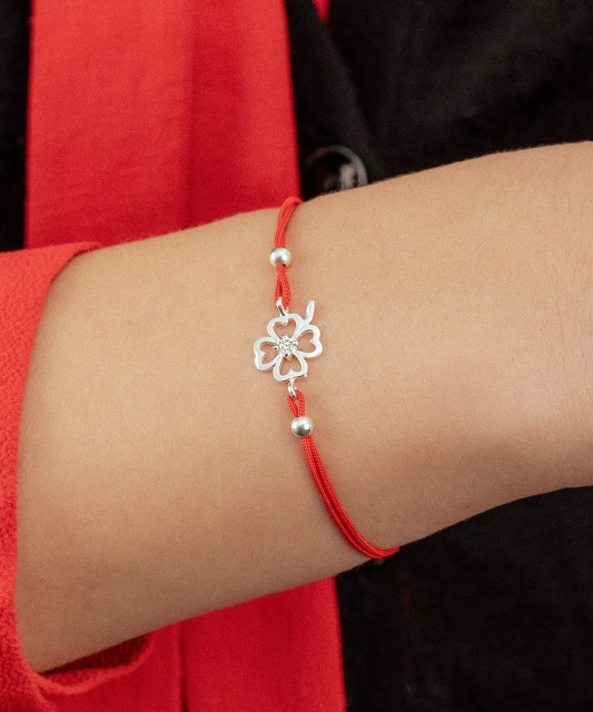 Red string bracelet with a silver pendant