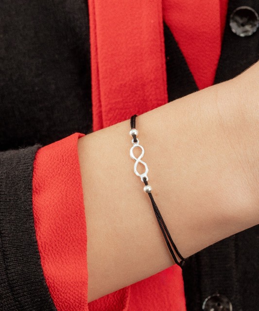 Black string bracelet with a silver pendant