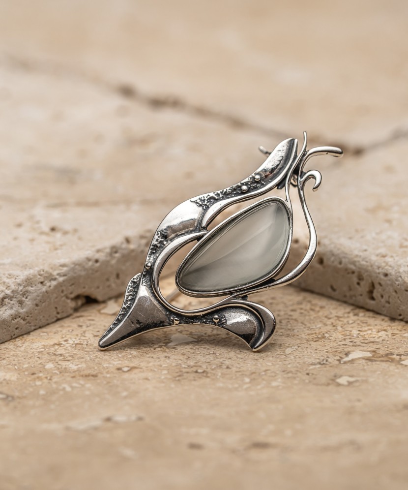 Hopeinen rintaneula kissansilmäkiven kanssa