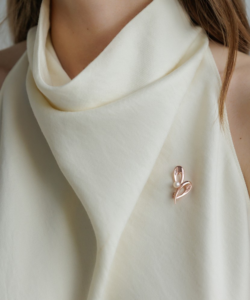 Kullattu hopeinen rintaneula helmillä