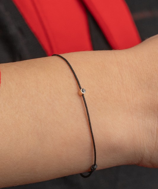 Musta lankarannekoru mustalla timantilla ja keltaisella kullalla