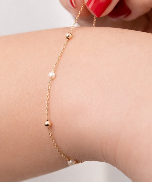 Kultainen rannekoru helmillä