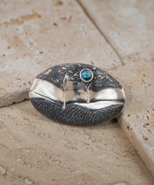 Hopeinen rintaneula helmiäisellä