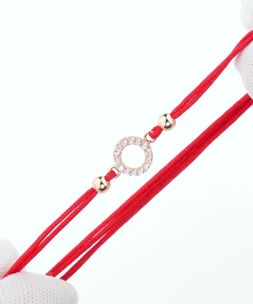 Red string bracelet with a gold pendant and zirconium