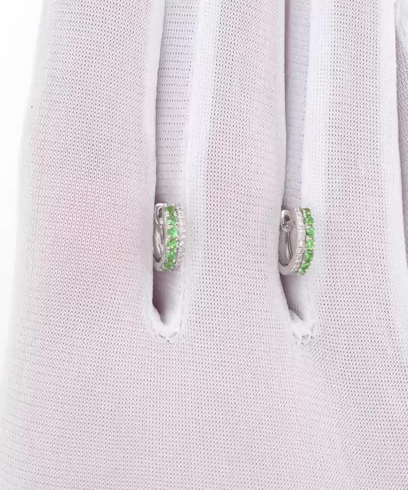 Valkokultaiset korvakorut timanteilla ja vihreällä granaatilla