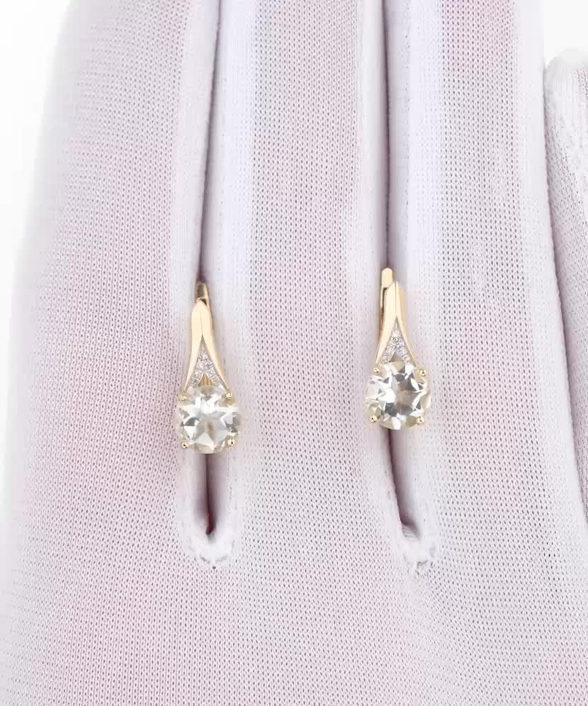 Keltakultaiset korvakorut timanteilla ja vihreällä ametistilla