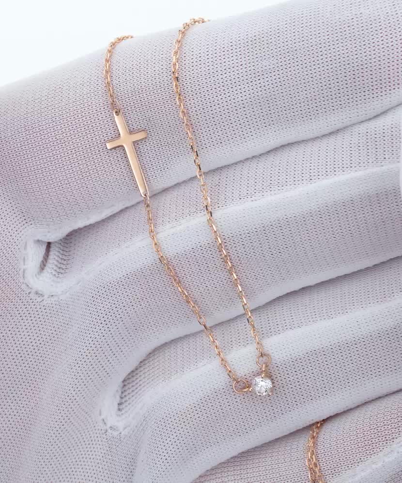 Kultainen zirkoniriipuksella ja ristillä