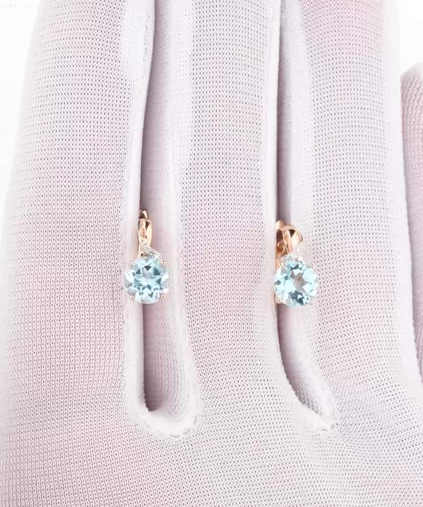 Kultaiset korvakorut timanteilla ja topaseilla