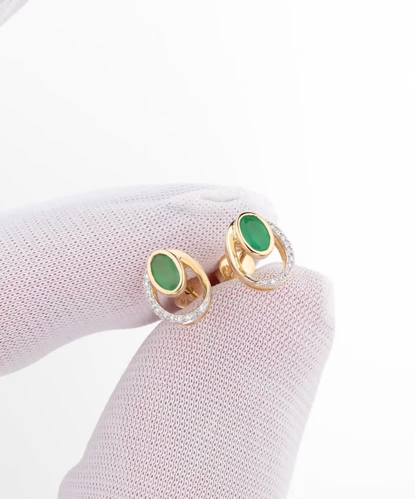 Keltakultaiset korvakorut timanteilla ja smaragdeilla