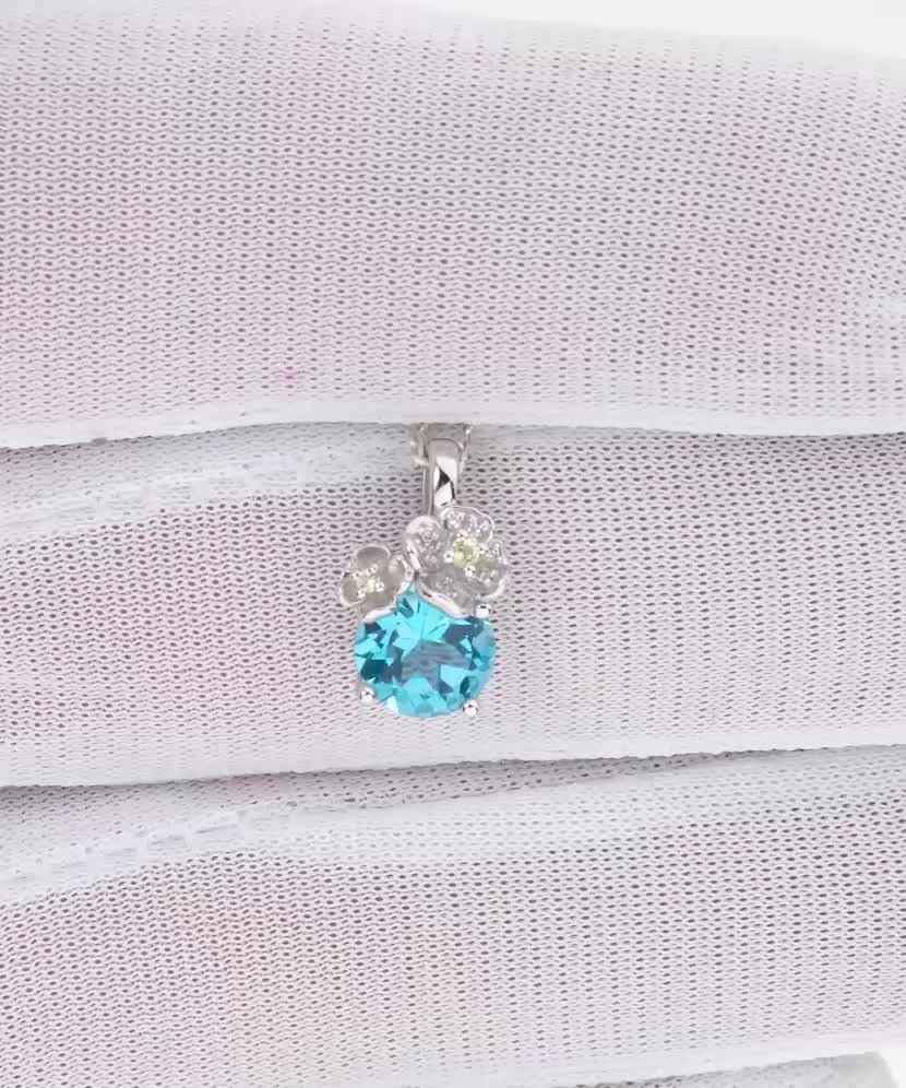 Valkokultainen riipus topaasilla, timanteilla ja peridooteilla