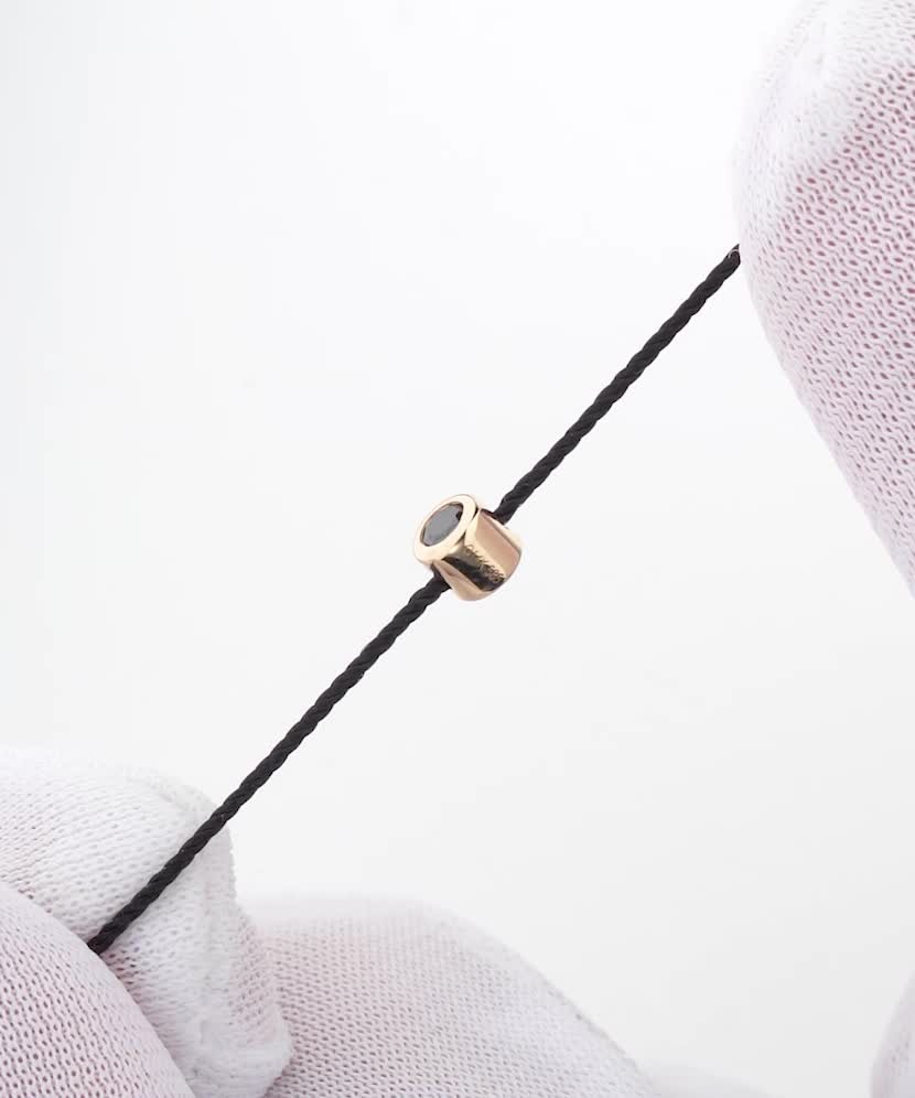 Musta lankarannekoru mustalla timantilla ja keltaisella kullalla